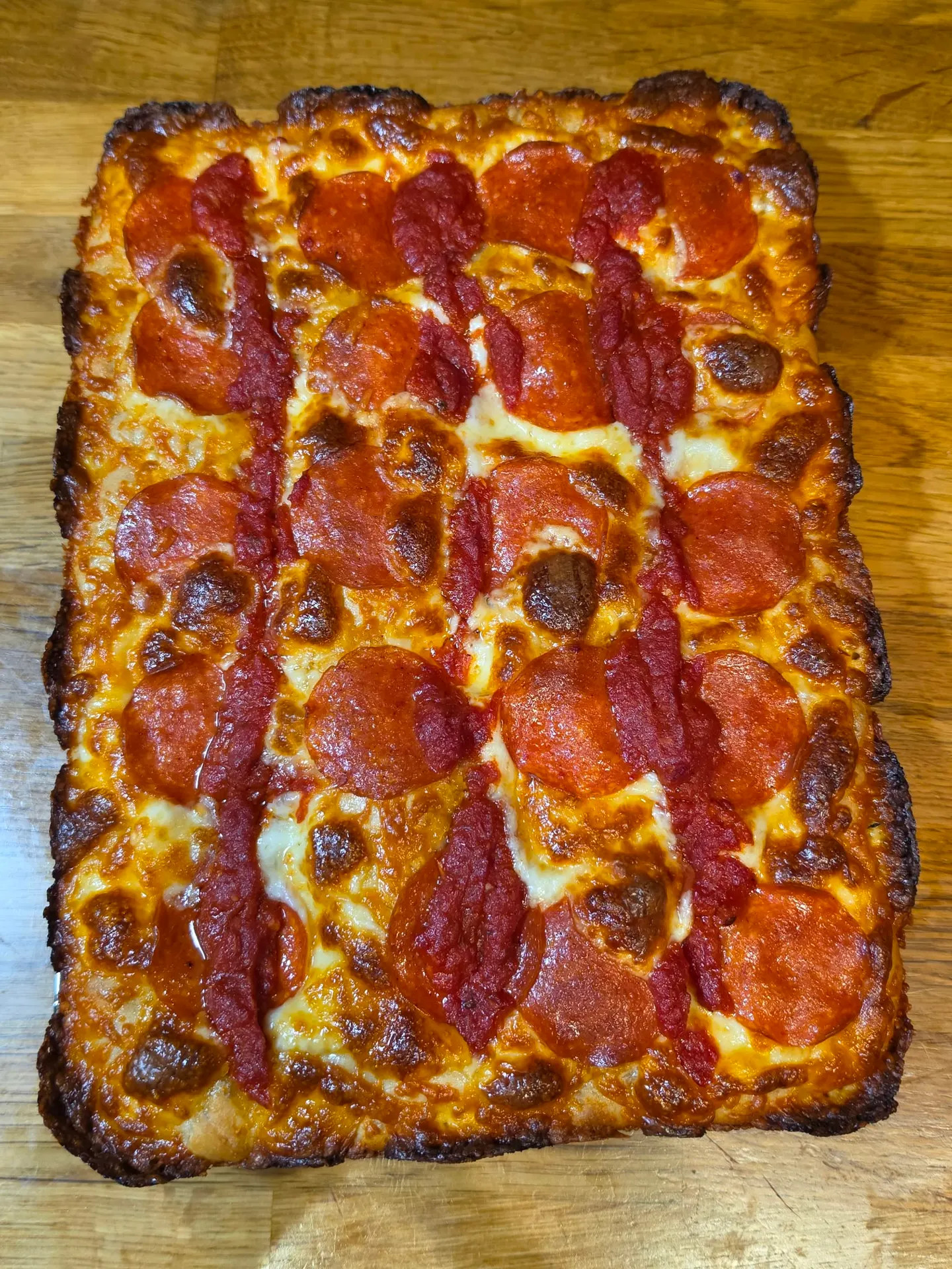 Detroit-style pepperoni pizza from above, crispy cheese edges